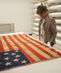 Mary Gallagher, Collections Manager at BCHS, caring for a historic flag at BCHS.